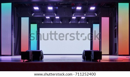 Interior of a conference concert hall or theatre with LED screen on scene and red seats