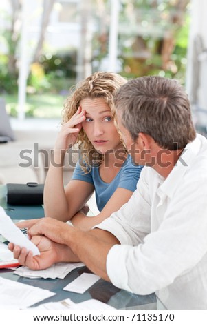 Desperate couple calculating their domestic bills at home