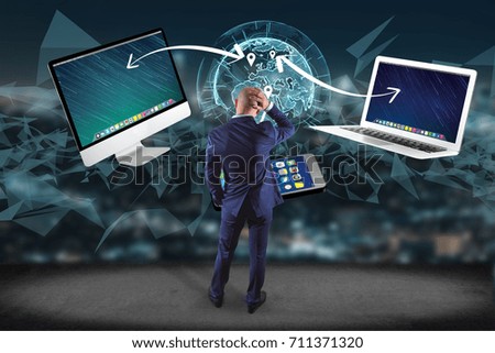 View of a Businessman in front of a wall with Computer and devices displayed on a futuristic interface with interantional network - Multimedia and technology concept