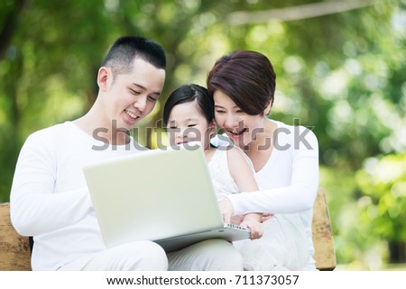 Young happy Asian family spending time together at the park.