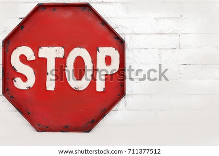 red stop symbol on a white brick wall, isolated object. symbols