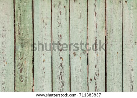 Old rural fence. Shabby Wood Background with old light green paint. Close up