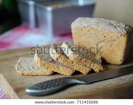 Fresh bread on a rye ferment without yeast cut on a wooden cutting board on plaid tablecloth