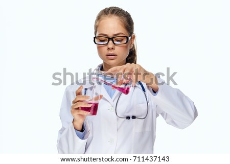 doctor pours a pink liquid from a beaker into a flask on an isolated background, medicine                               