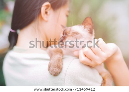 Young woman holding pretty cat, pet lover concepts.
