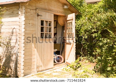 Small house cabin shed together with rich green vegetation and a lovely summer meadow Royalty-Free Stock Photo #711461824