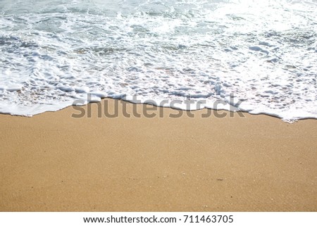 Close up wave of blue ocean on sandy beach. Background concept of summer.