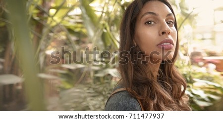 Beautiful young multicultural woman in tropical city park.