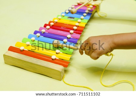 The child's hands playing xylophone