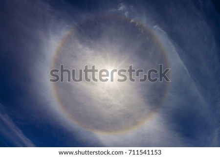 Solar halo in a slightly cloudy blue sky