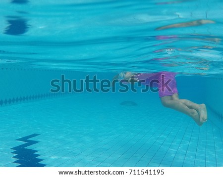Swimming pool with tile floor and reflection and baby.

