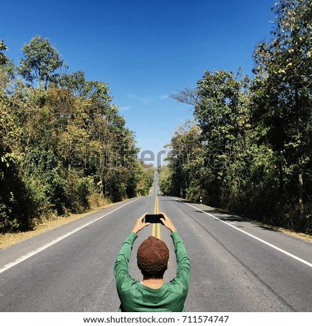 A man taking photo with long road scene