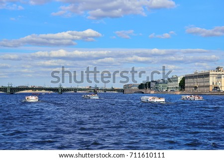 Pleasure boats float in the waters of the Neva river on the background of the Trinity bridge in Saint-Petersburg
