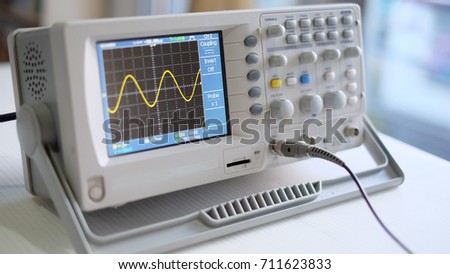 Yellow sine wave on digital oscilloscope Royalty-Free Stock Photo #711623833