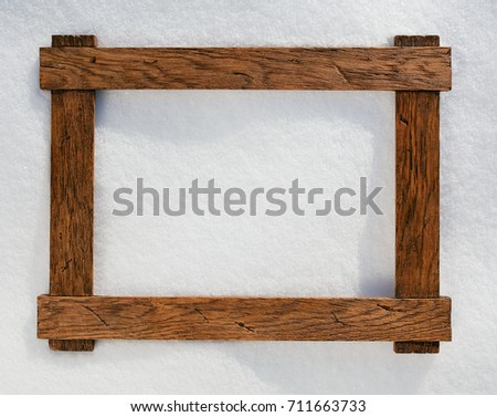wooden frame on natural snow, copy-space background