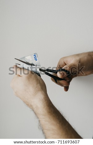 man cutting visa card. scissors cut visa card. man against bank
