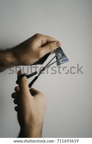 man cutting visa card. scissors cut visa card. man against bank