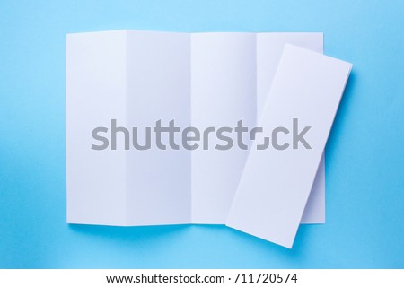 Leaflet blank Four-fold white paper brochure mockup on blue background. top view