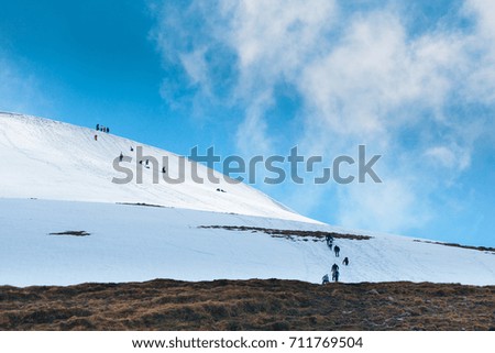 Tourists climbs for camping to the snow-capped mountain top. Sunny day, good weather. Unidentified persons.