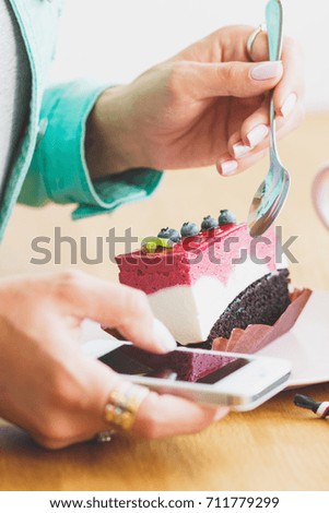 Woman takes a picture piece of dessert on the plate, soft focus background