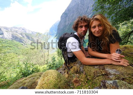 Couple of hikers take a picture with the idyllic Naerofjord on background