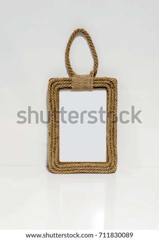 A photo frame made of hemp rope against white wall background.