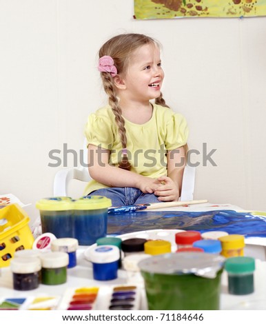 Happy child painting in preschool.