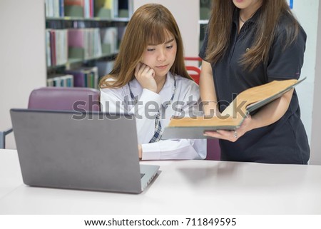 Teacher teaches students using laptops in classroom.