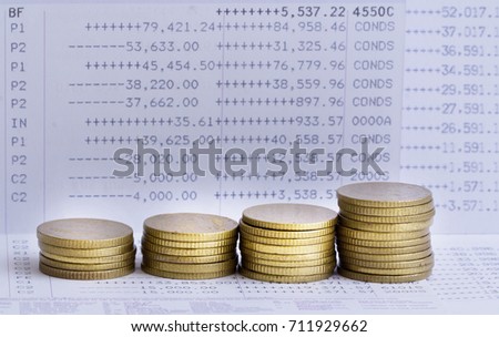 Stacks of gold coins on banking account in the background
