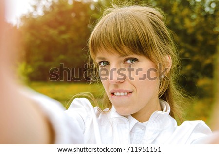 the girl makes a portrait selfie in autumn park