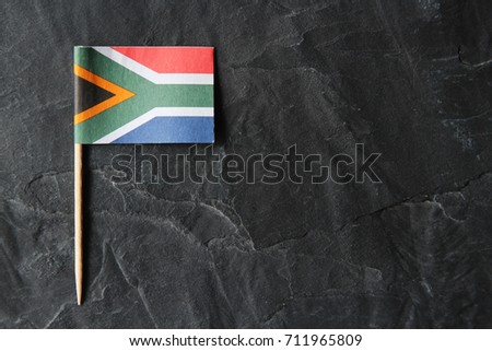 A South African flag toothpick on a black slate background. Heritage day concept image.
