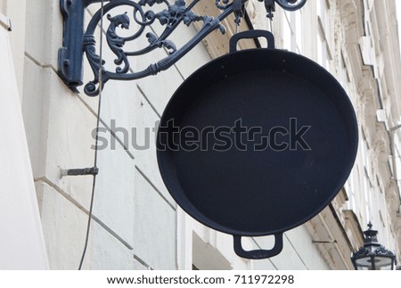 Black pan hanging vertically on the wall as a house sign