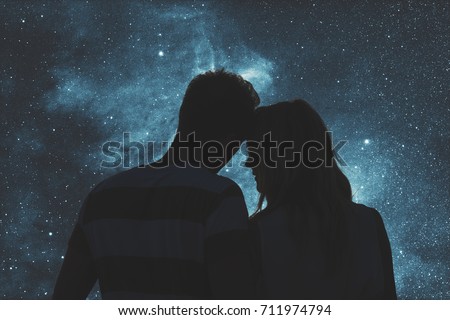 Silhouettes of a young couple under the starry sky. Elements of this image are my work. Royalty-Free Stock Photo #711974794