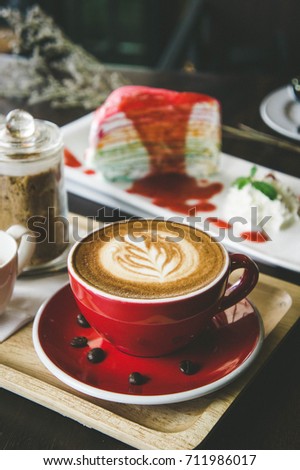 aroma coffee red cup latte art and tasty cake on wood table in coffee shop with vintage dark tone and copy space