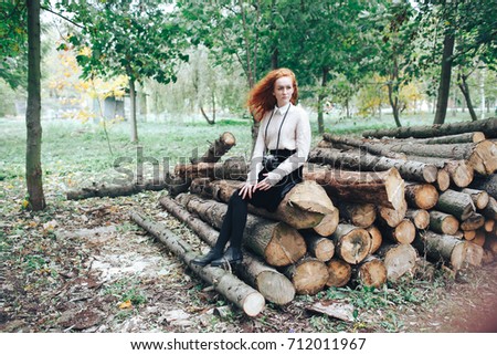 redhead girl holding camera in autumn park
