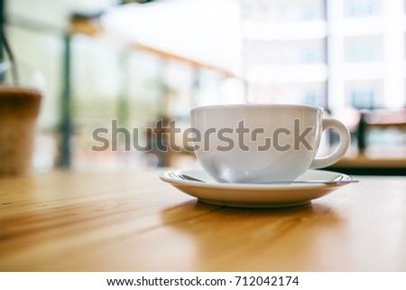 Coffee cup display on wooden table in coffee shop and restaurant in the morning.