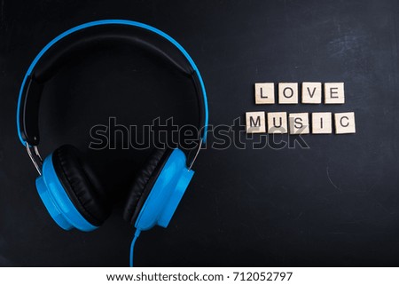 text love music and headphones on black background
