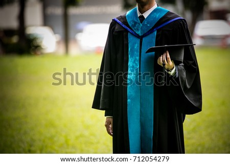 Hand of graduate holding black hat, graduation and successful concept.
