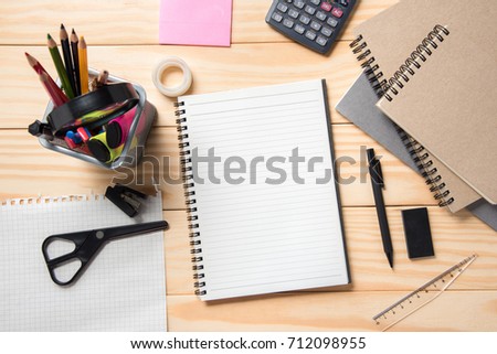 Blank Notepad with stationery, office supplies on wooden table.