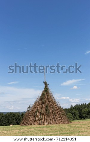 for a midsummer festival bonfire on a very sunny day in august in south germany you see woodpile beside a tent right before burning for a huge fire