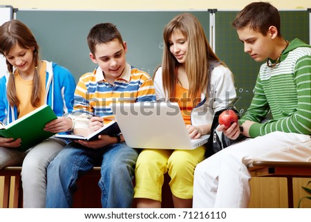 Portrait of clever students sitting in classroom and doing schoolwork