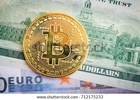 The gold coin of bitcoin lies on dollar and euro.