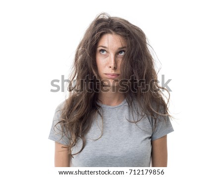 Angry young woman having a bad hair day, her long hair is messy and tangled Royalty-Free Stock Photo #712179856