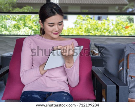 young pretty Asian woman Freelance using smart digital tablet for research information for next project at home.