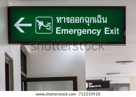 Sign of emergency exit  in Thai and English text at doorway