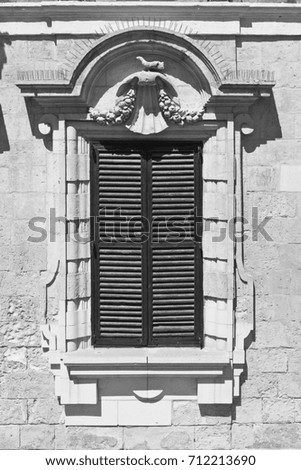 Building with traditional maltese window in historical part of Valletta. Black and white picture