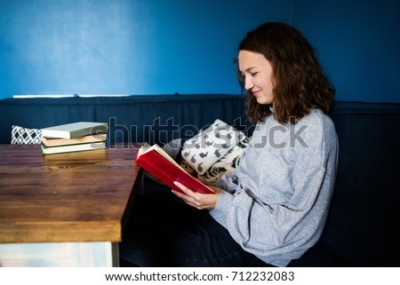 girl reading a red book at home