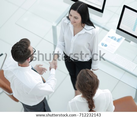handshake manager and employee near the workplace