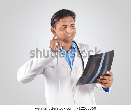 Doctor with stethoscope happy to see report over a gray background