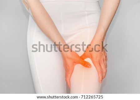 woman with leg pain. Female holding hand to spot of Thigh. Concept photo with read spot indicating location of the pain.
